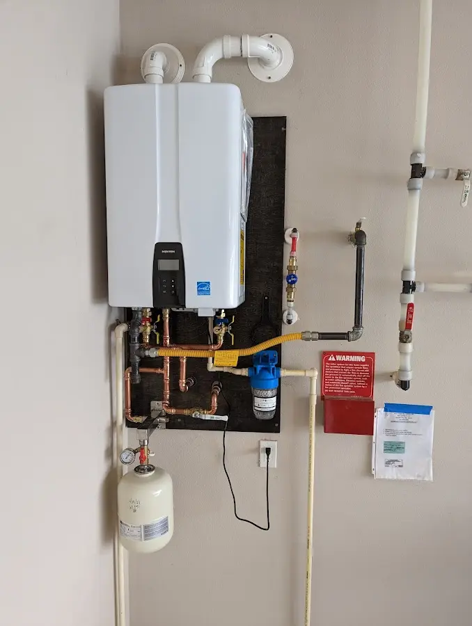 Professional plumber installing copper piping in a Wollochet home